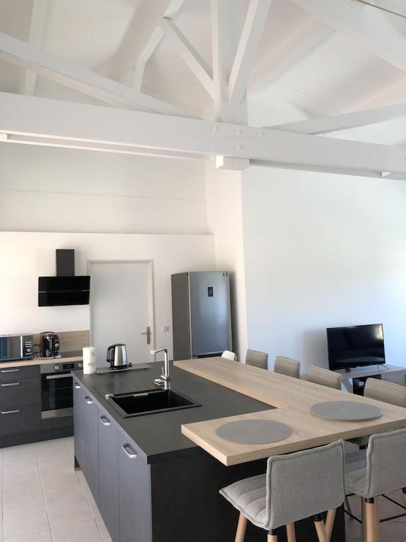 une cuisine avec un évier et un comptoir avec des chaises dans l'établissement Mazet Les Issambres / Ste-Maxime, à Roquebrune-sur Argens