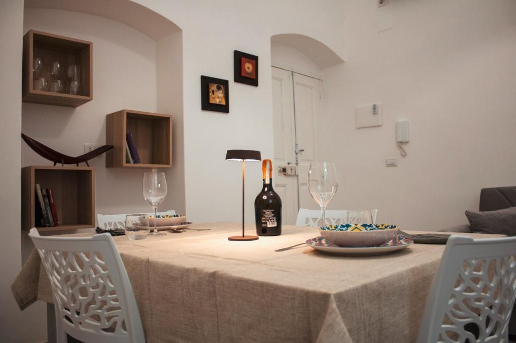 una mesa de comedor con una botella de vino y copas en Casa Morrone Residence, en Corato