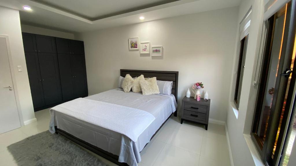 1 dormitorio con 1 cama con sábanas y almohadas blancas en The Roseville en Ocho Rios