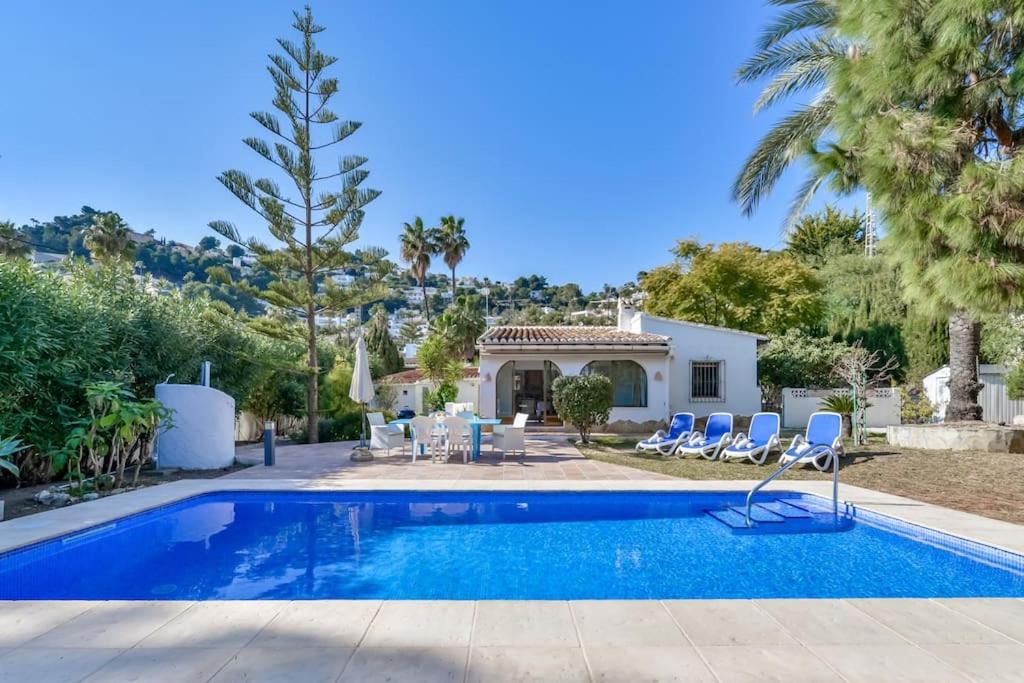 een villa met zwembad en palmbomen bij Villas Guzman - Beniali in Moraira