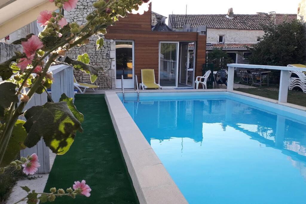 een zwembad met blauw water voor een huis bij Grande maison de famille avec piscine couverte in Nieulle-sur-Seudre