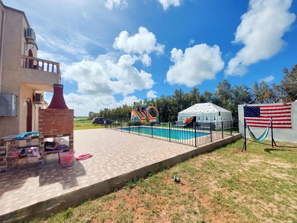 un parque infantil con piscina y bandera americana en American Farm Villa Grand Casablanca/El Jadida 