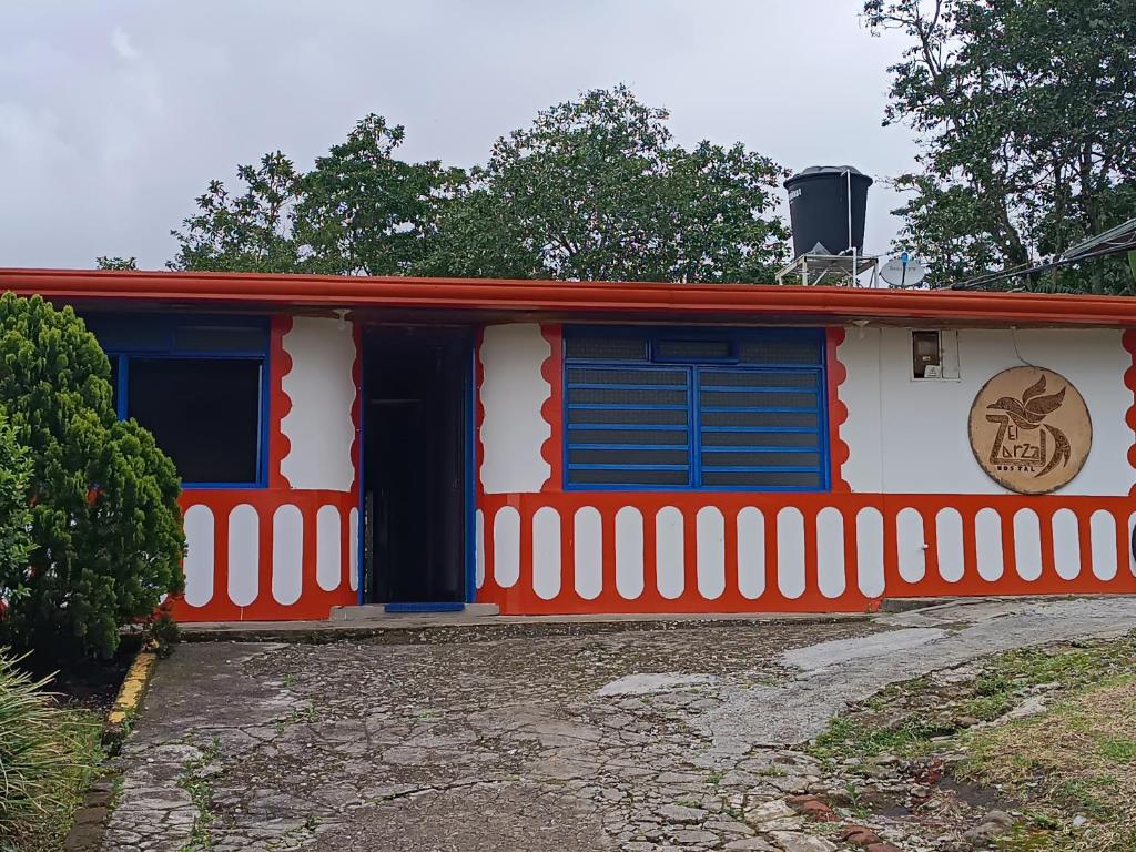 a red white and blue house with a fence at El ZORZAL in Salento