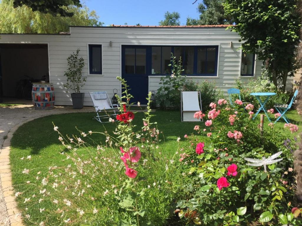 a house with a garden with roses in front of it at Le cabanon in La Rochelle