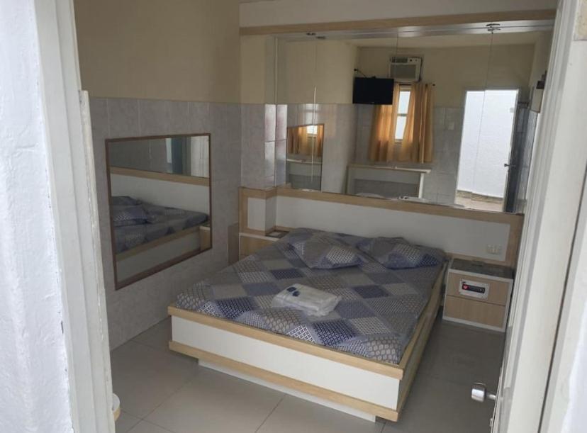 a small bedroom with a bed and a mirror at Hotel Central in Niterói