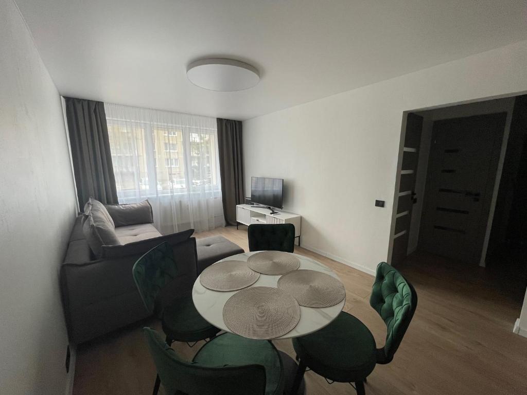 uma pequena sala de estar com mesa e cadeiras em MB Livinga Vieno miegamojo apartamentai Ventos g em Mažeikiai