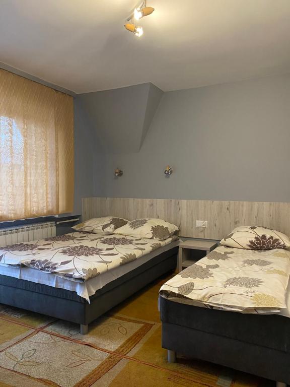 1 dormitorio con 2 camas y ventana en Domek Okno na Tatry - Dom na wyłączność, en Poronin