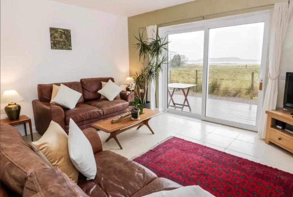 a living room with a couch and a tv at Sealladh in Port Appin