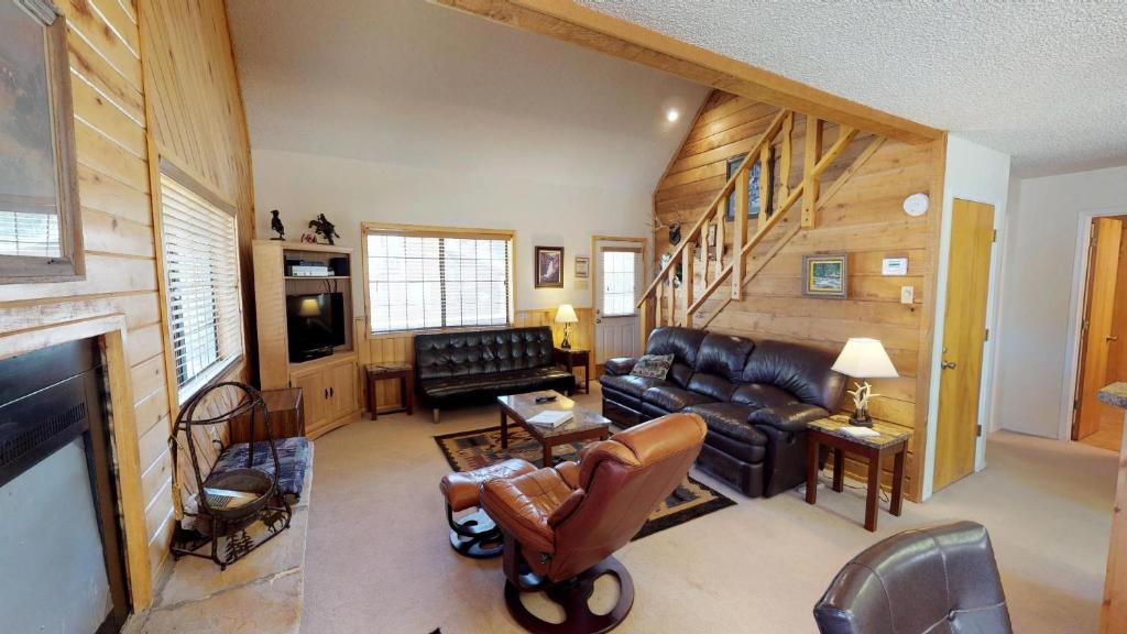 a living room with leather furniture and a fireplace at Our Red River Cabin With High Speed Wifi in Red River