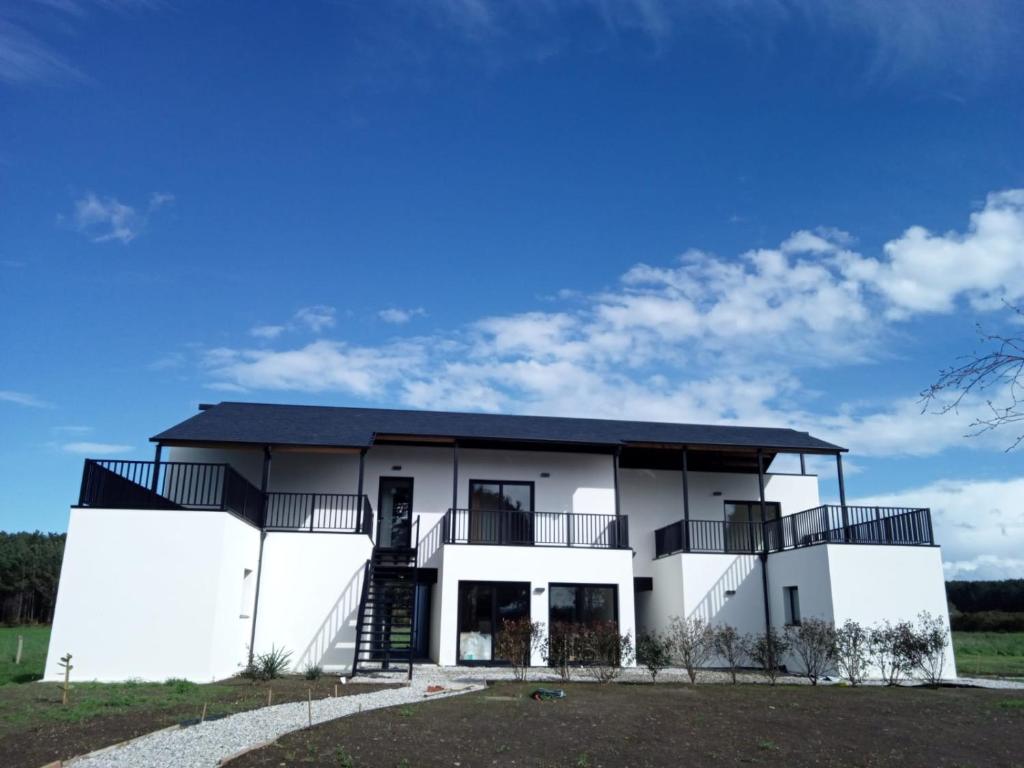 une maison blanche avec un toit noir dans l'établissement Anam Cara House, à Serantes