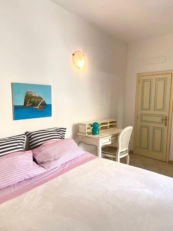 um quarto com uma cama branca e uma mesa em Casa vacanza maronti em Ischia