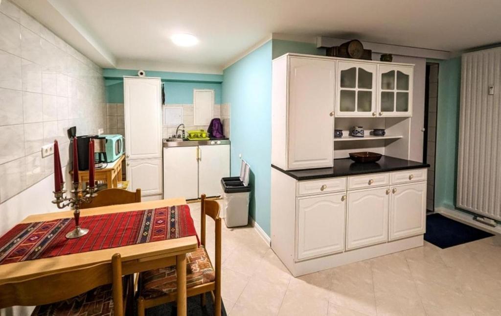 a kitchen with white cabinets and a table in it at Ferienwohnung Lena in Schwerin- Wickendorf in Schwerin
