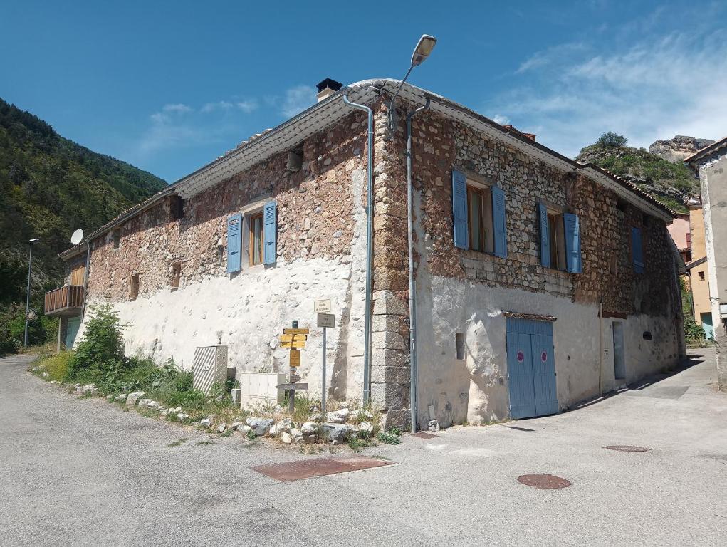 un vieux bâtiment en briques avec une porte bleue dans l'établissement LE GRAND LOGIS, suite Santorin avec spa insolite privatif, 
