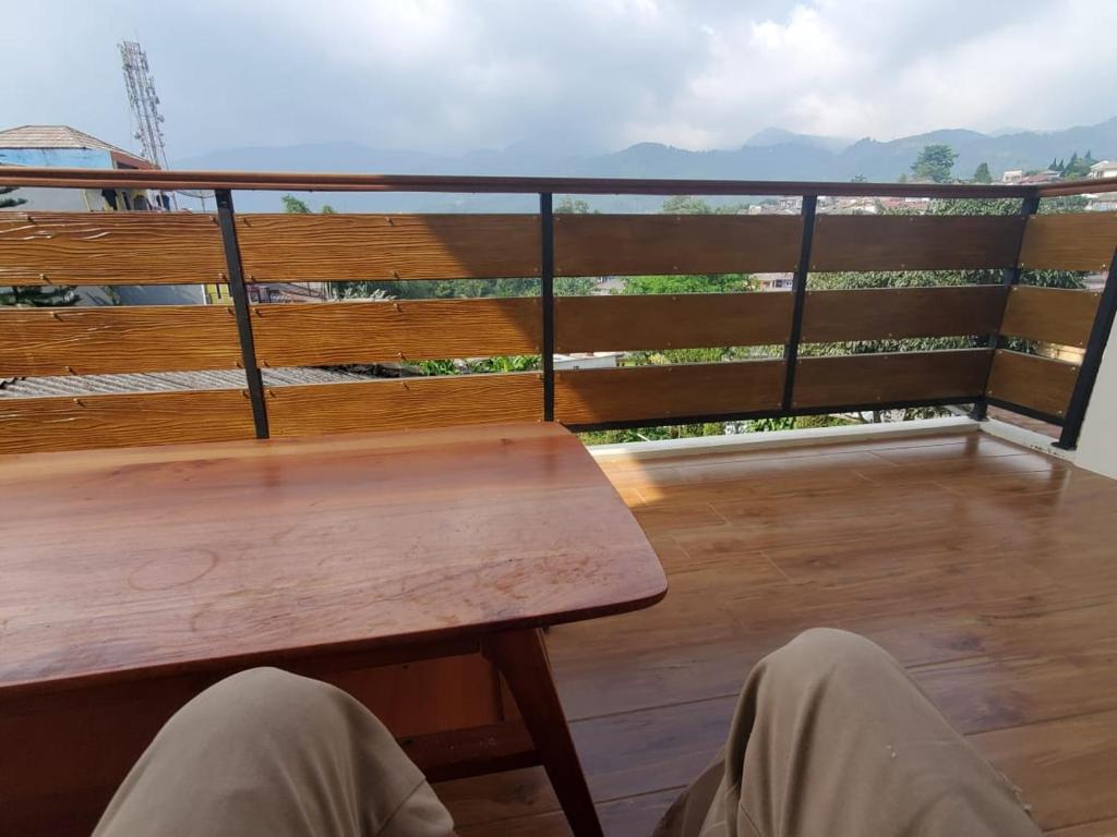 d'une table en bois sur un balcon avec vue. dans l'établissement Bobo Queen House 5 villa baba ( mountain view), à Puncak