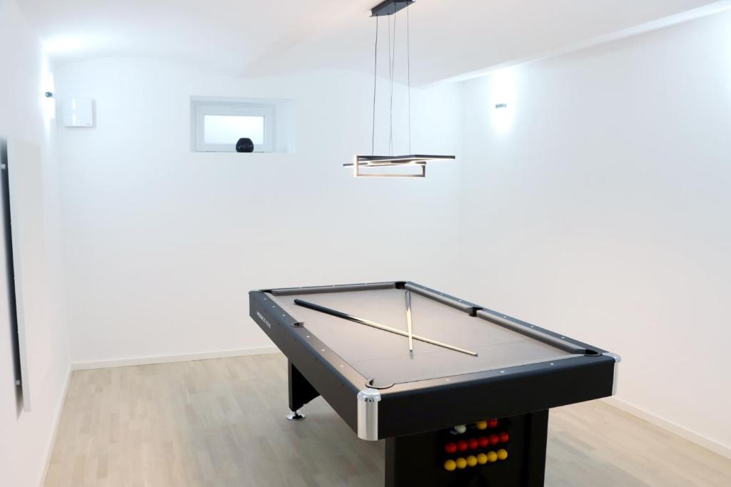 stół do ping ponga w białym pokoju z: w obiekcie Lumi - modern apartment with parking w Mariborze
