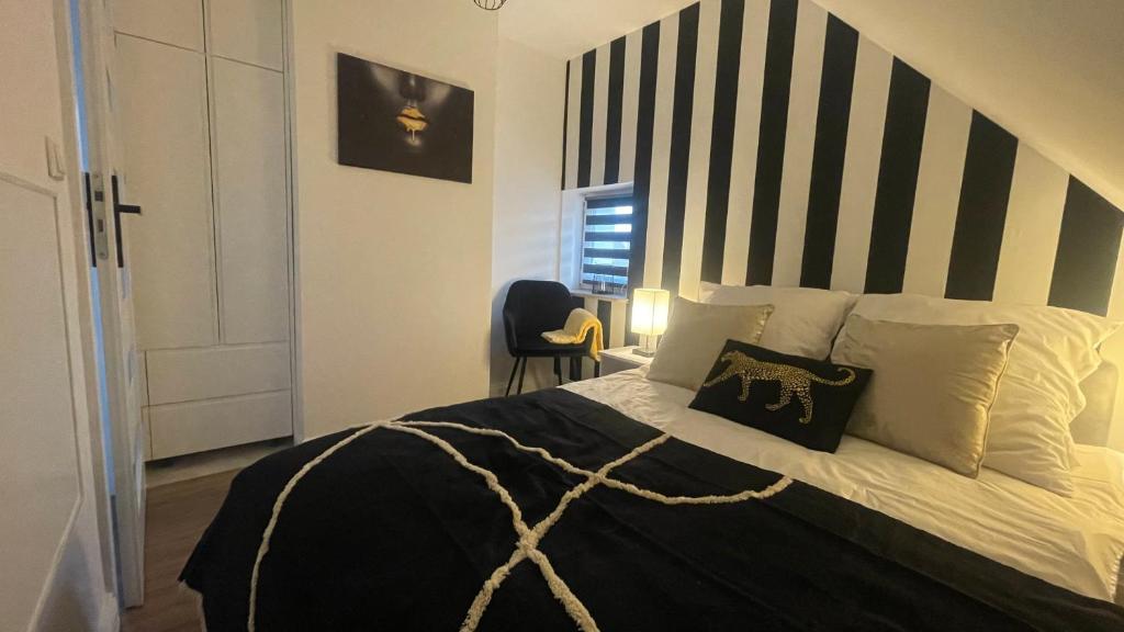 a bedroom with a bed with a black and white striped headboard at Apartament Loft in Elblag