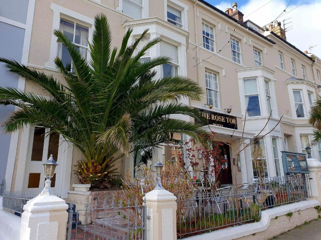 a building with a palm tree in front of it at Rose Tor Hotel in Llandudno