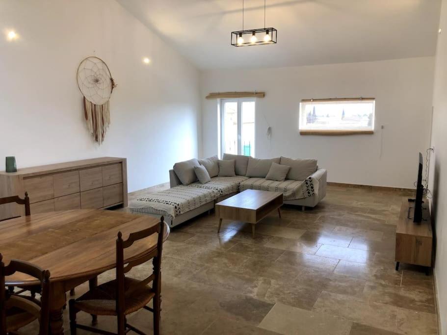 un salon avec un canapé et une table dans l'établissement Appartement au milieu des oliviers, à Rasteau