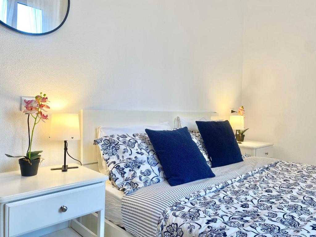 um quarto com uma cama com almofadas azuis e brancas em TERMINAL Apartment em Gênova