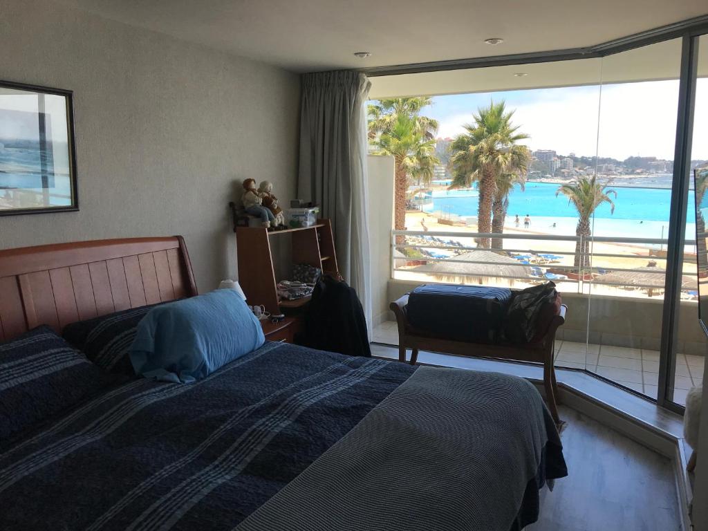 um quarto com uma cama e vista para uma piscina em San alfonso timonel em Algarrobo