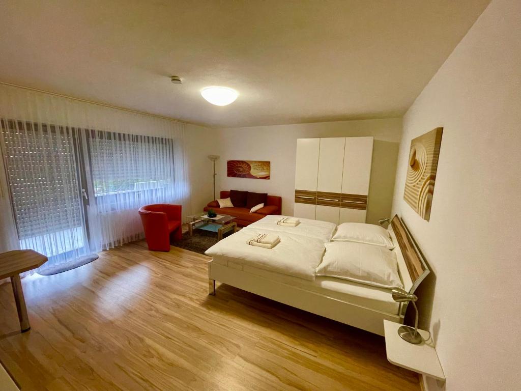 ein Schlafzimmer mit einem Bett und ein Wohnzimmer in der Unterkunft Ferienwohnung David im Haus Waldblick - Bad Bergzabern in Bad Bergzabern