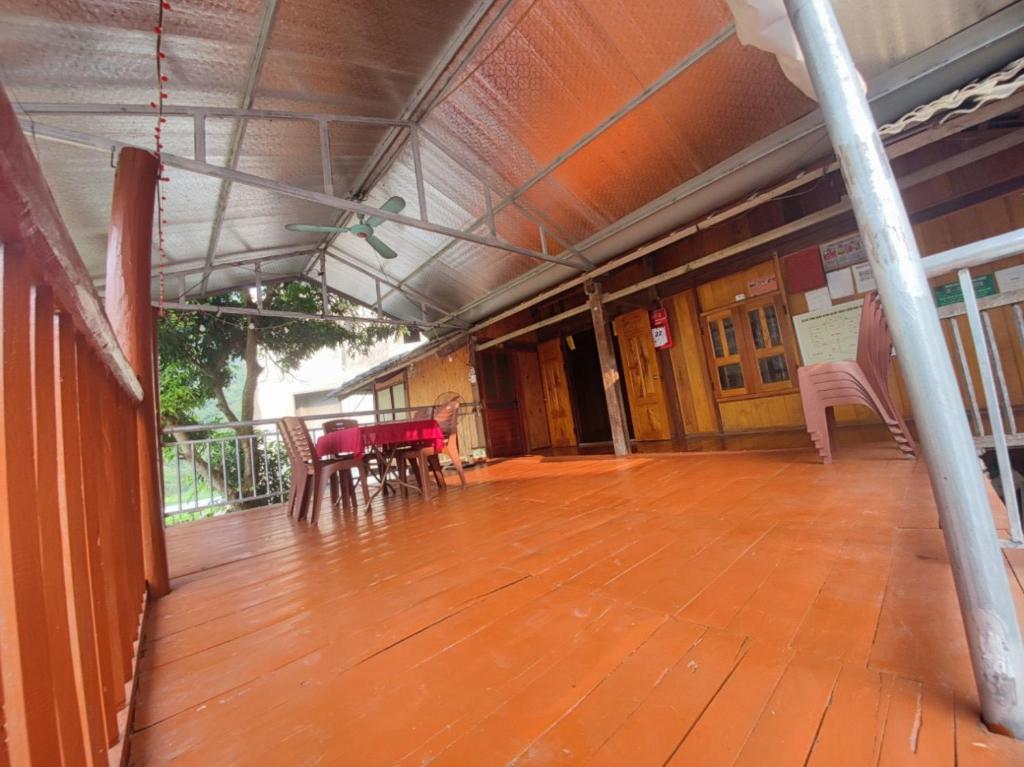 a large deck with wooden floors and tables and chairs at Anh dược homestay in Bak Kan