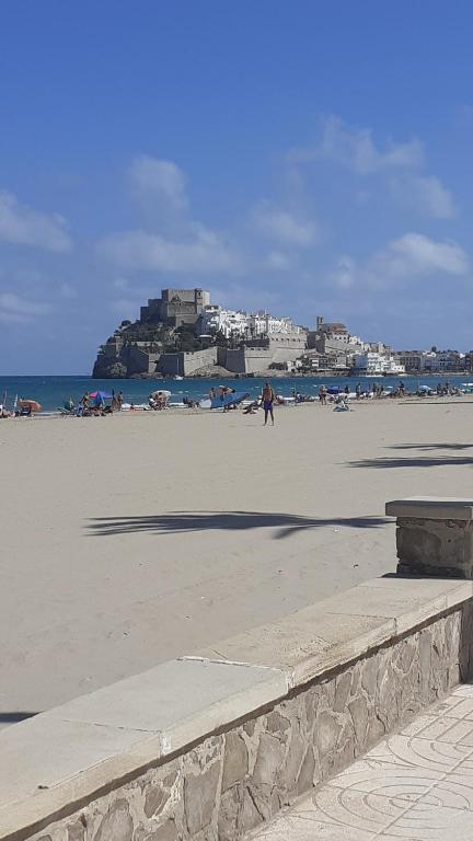 a beach with people on the sand and the ocean at App.Pradomar Peñiscola in Peniscola