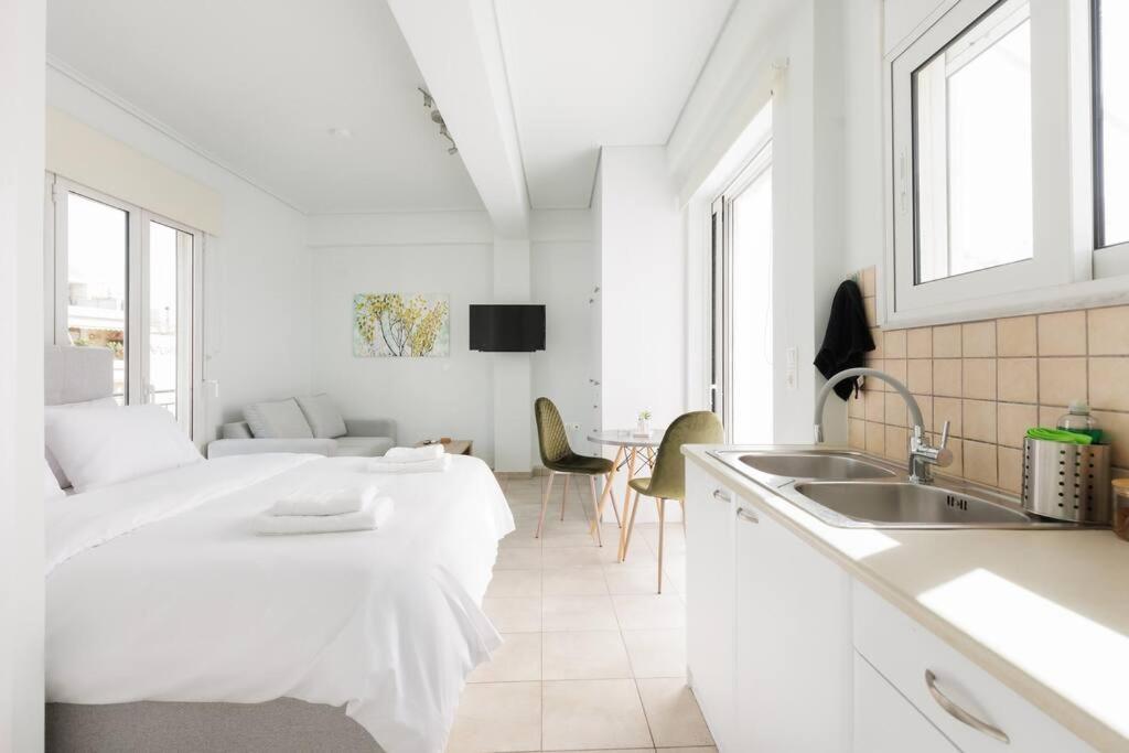 a white room with a bed and a sink at Adorable sunny studio with private balcony I in Athens