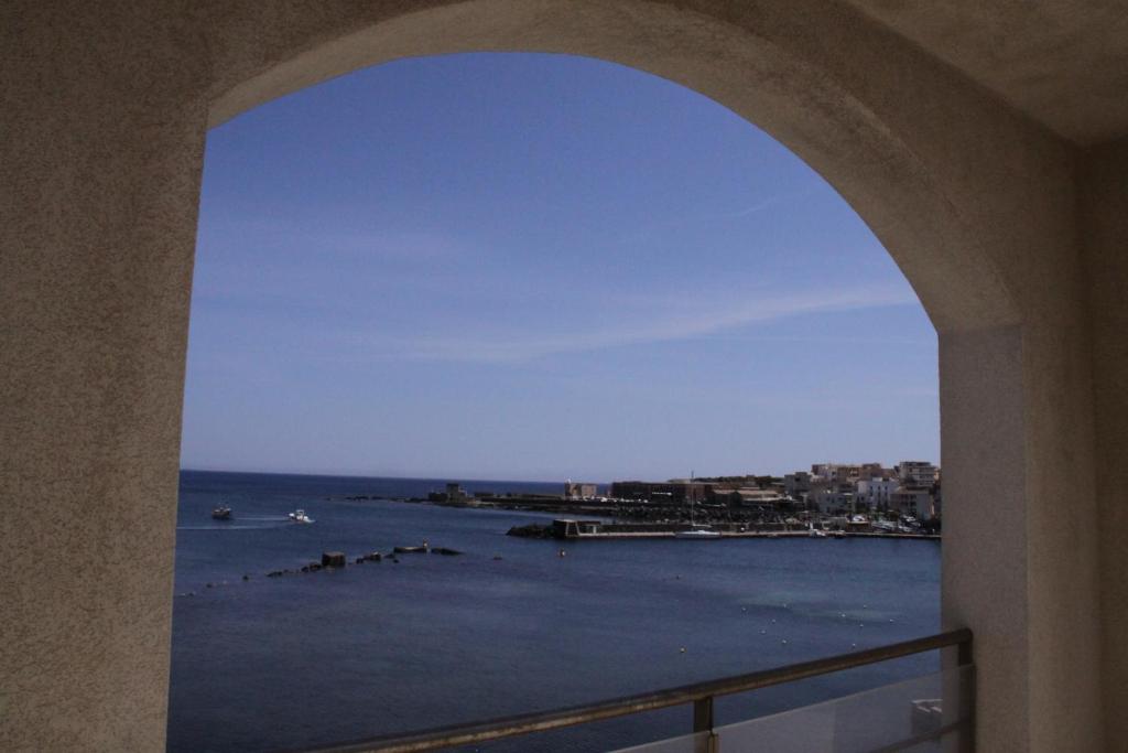 una vista del océano a través de un arco en Yacht Marina Hotel en Pantelleria