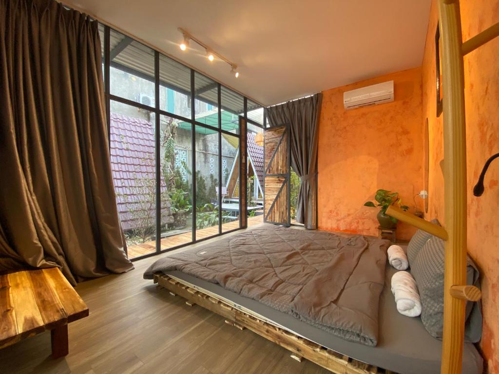 1 dormitorio con cama y ventana grande en Trầm Homestay, en Thôn An Hòa