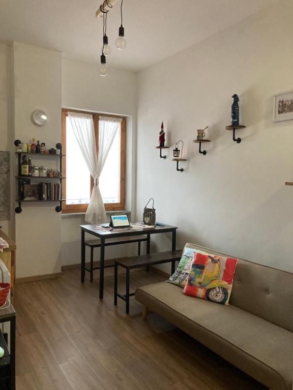 ein Wohnzimmer mit einem Sofa und einem Tisch mit einem Laptop in der Unterkunft Borgo Carletto Roburent - Immersi nella natura in San Giacomo