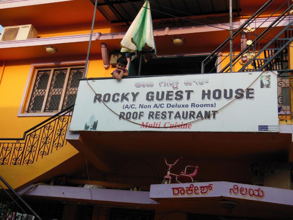 a sign for a rocky guest house on a building at Rocky Guesthouse in Hampi