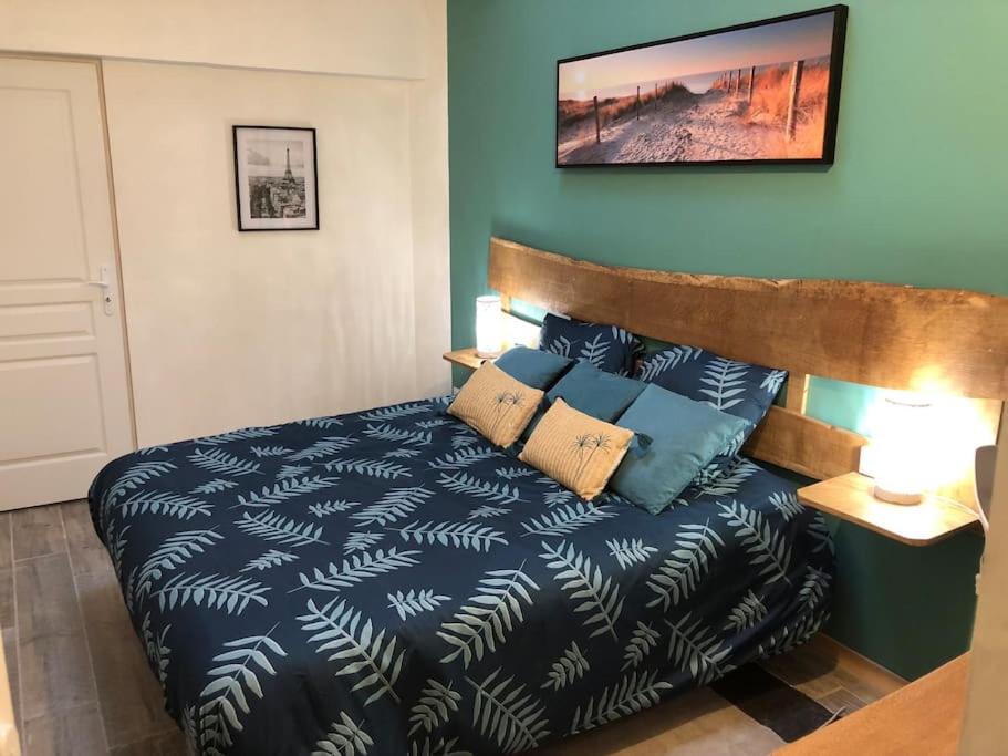 une chambre avec un lit recouvert d'une couette bleue dans l'établissement L'appart d'Antoine, à Saint-Quentin