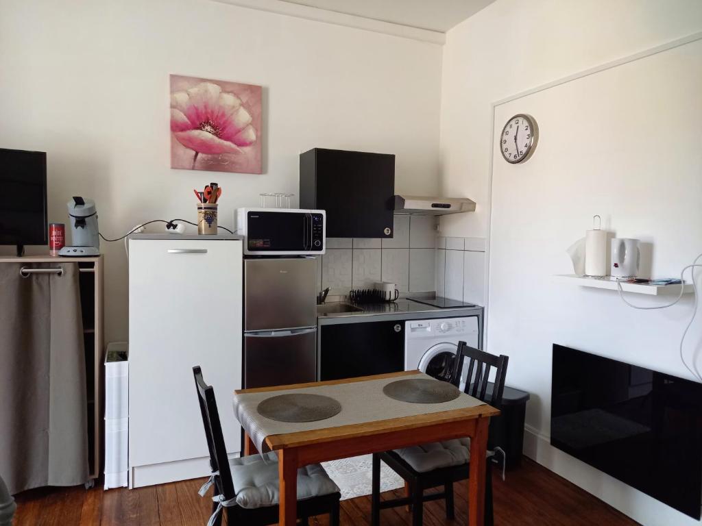 a small kitchen with a table and a refrigerator at Studio 253, classé 2 étoiles, proche des thermes in Vittel