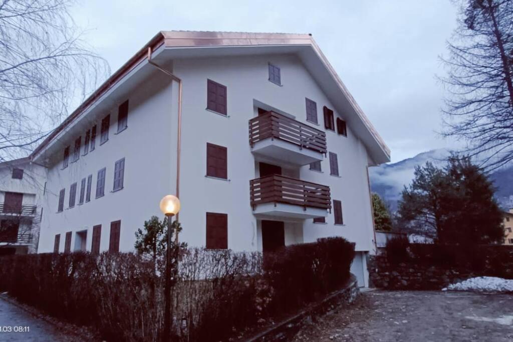 Grazioso Bilocale in Val Vigezzo في Craveggia: مبنى ابيض فيه بلكونات جنبه