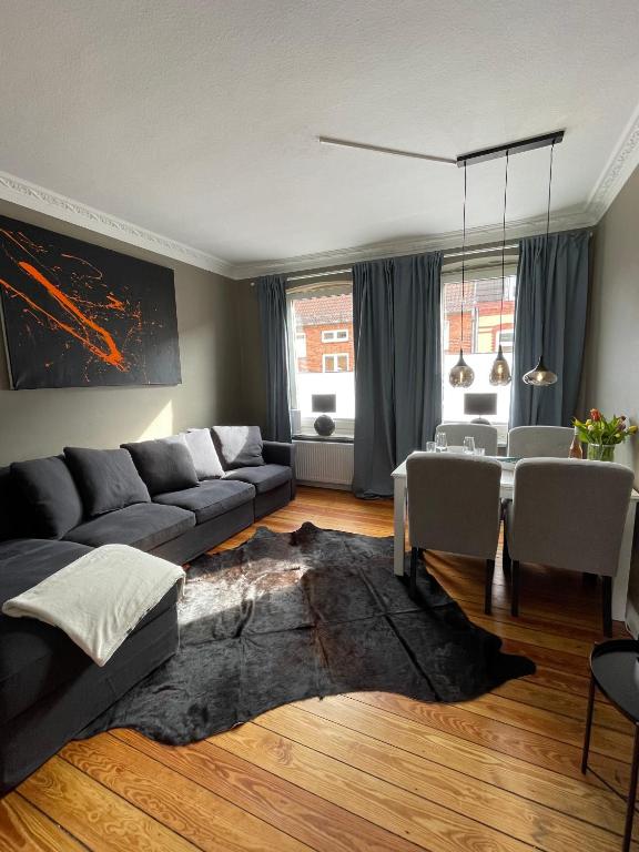 sala de estar con sofá y mesa en Altbaucharme Deluxe mit Balkon in zentraler Lage en Kiel