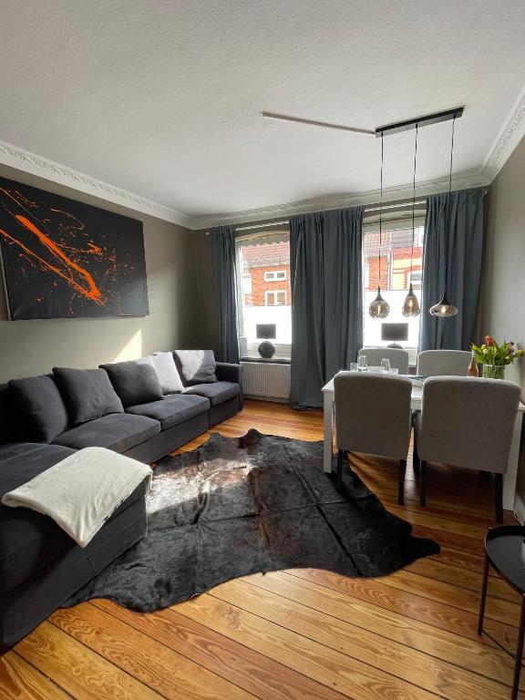 ein Wohnzimmer mit einem Sofa und einem Tisch in der Unterkunft Altbaucharme Deluxe mit Balkon in zentraler Lage in Kiel