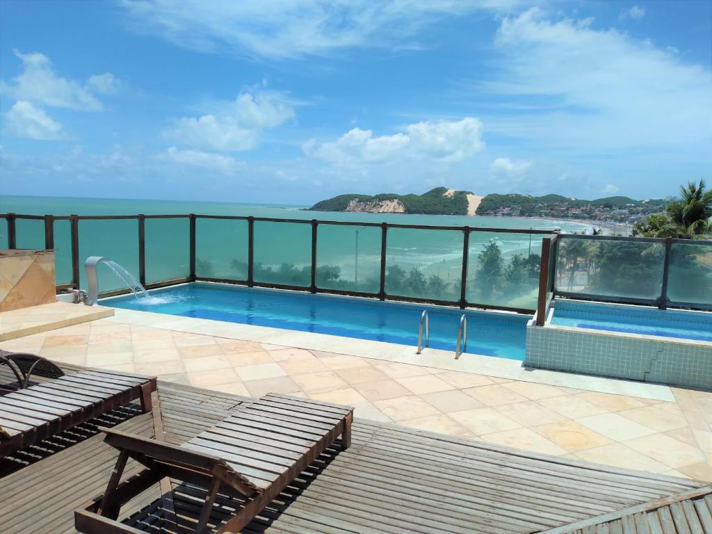 a swimming pool with a view of the ocean at Flat a beira mar, vista lateral - Araça 408 in Natal
