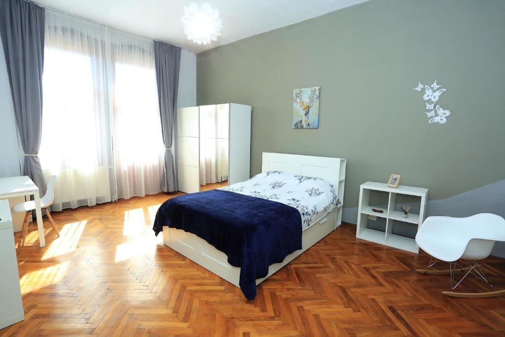 1 dormitorio con 1 cama, 1 mesa y 1 silla en Napoca Central Apartment en Cluj-Napoca