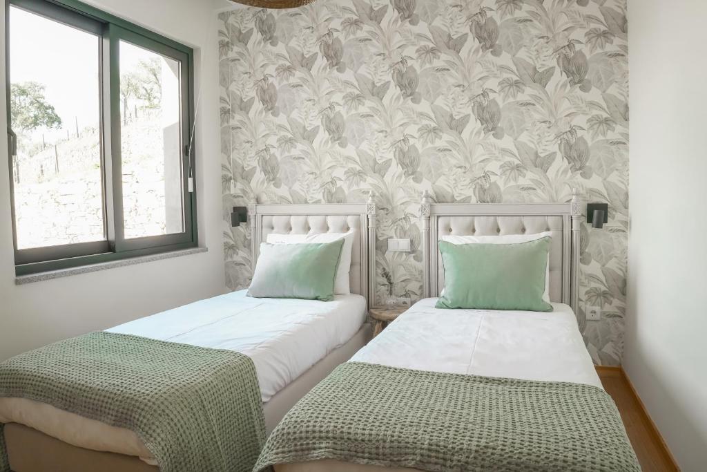 two beds sitting next to each other in a bedroom at Casa das Marucas in Peso da Régua