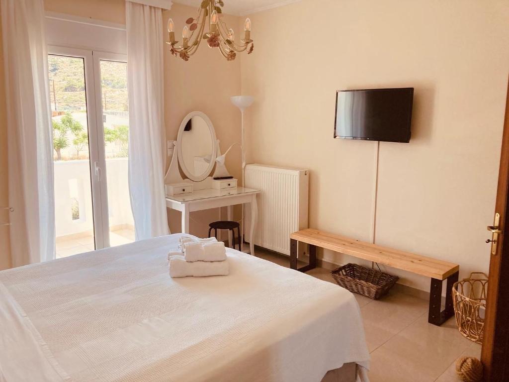 Habitación blanca con cama y espejo en Goldfish Seaside Luxury Houses en Kómi