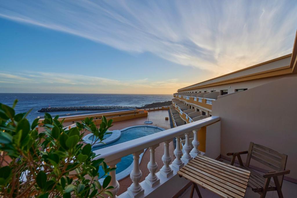 a balcony with a view of a swimming pool and the ocean at ABLANCAS - La Restinga in La Restinga