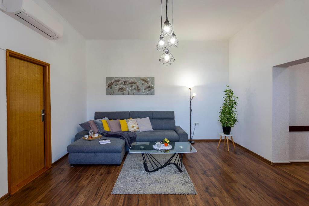 a living room with a blue couch and a table at Apartman LeMa in Pula