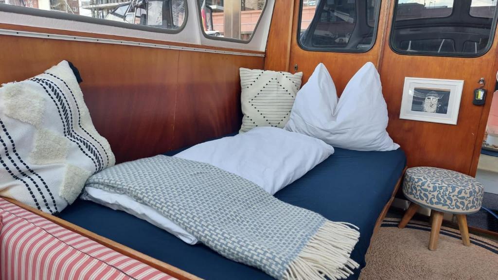 a bed with pillows sitting on top of a van at Motoryacht Bremen City in Bremen
