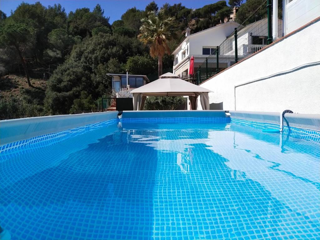阿根托納的住宿－Espacio Kybalion，一座蓝色的游泳池,拥有白色的建筑和树木