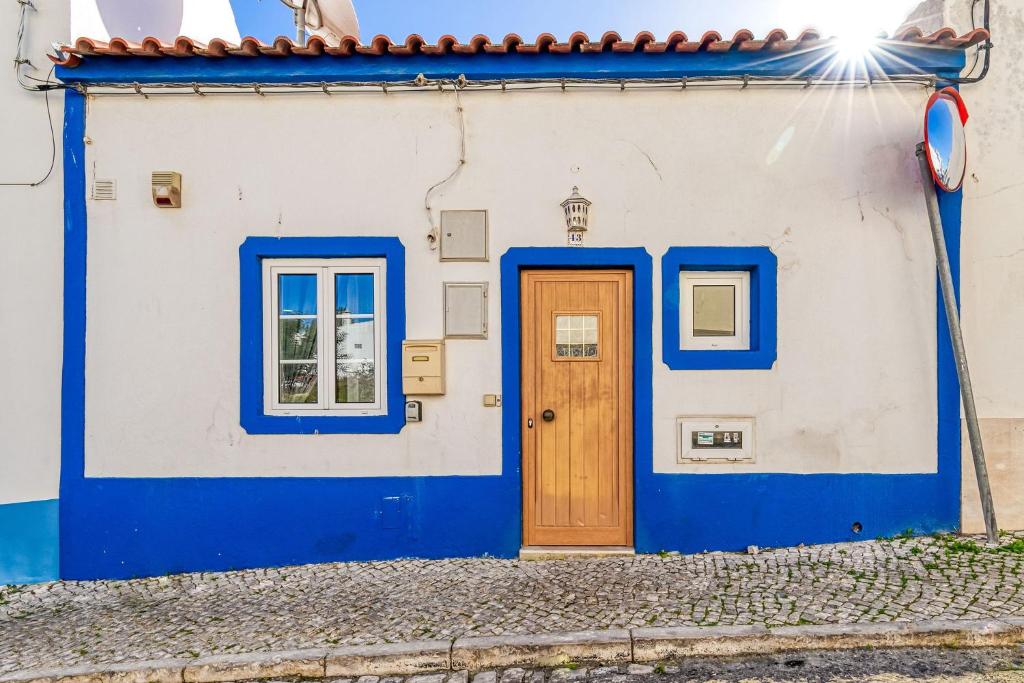 a blue and white house with a wooden door at Casa Perola -ocean view cottage in Carvoeiro