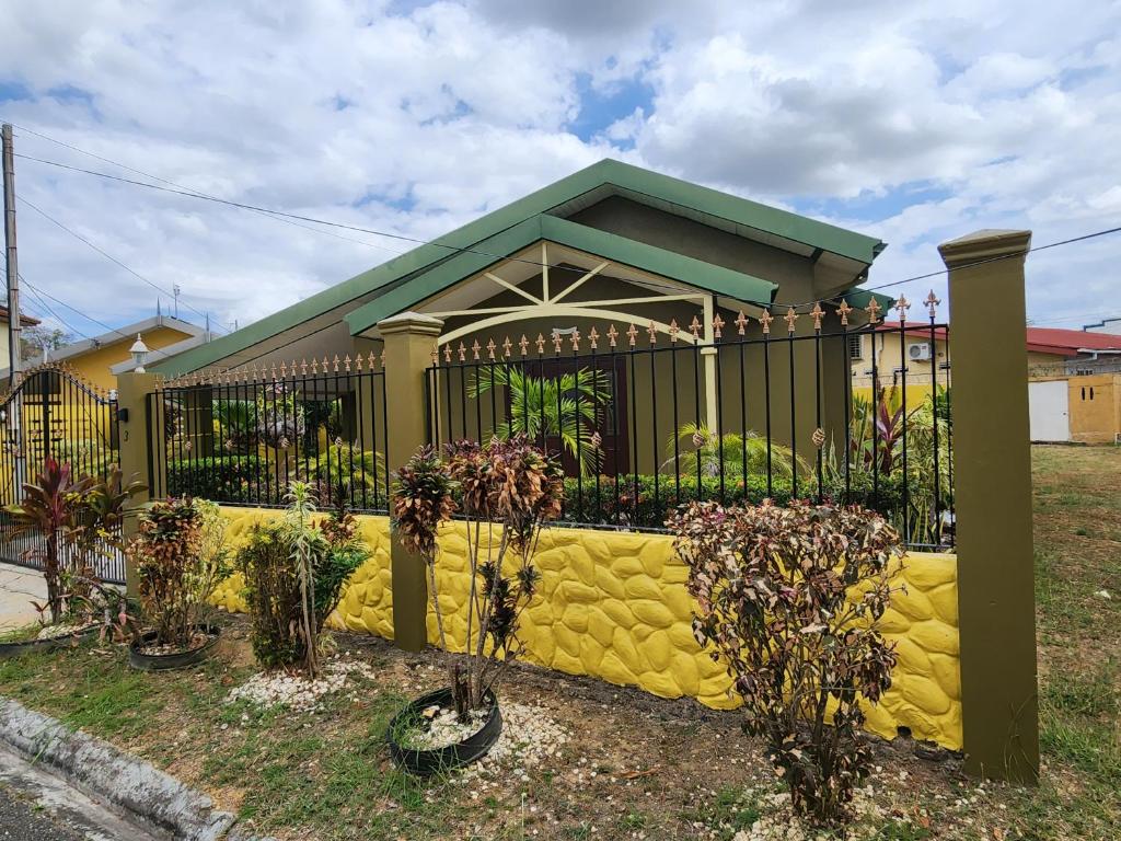 una recinzione di fronte a una casa con piante di Vista Stays ...Alluring Ambrosia near to Airport a Trincity 