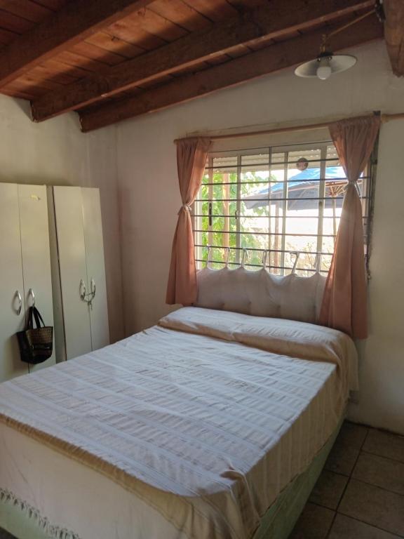 Schlafzimmer mit einem großen Bett und einem Fenster in der Unterkunft La fortuna in Las Toscas