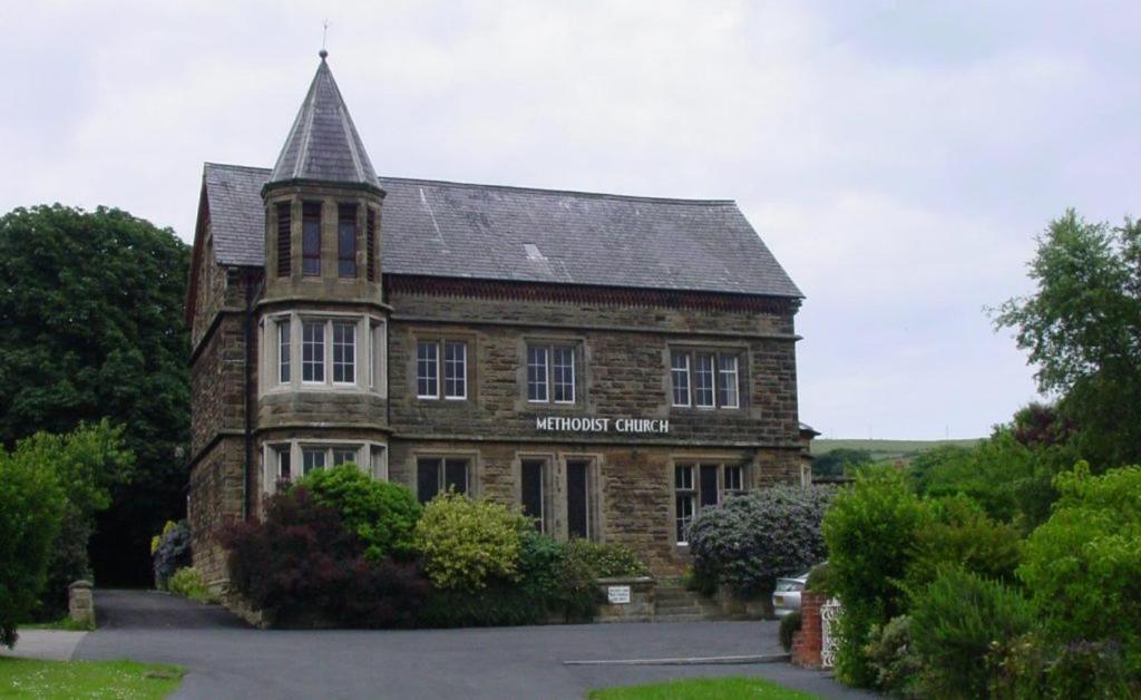 a large brick building with a tower on top of it at Church Holiday Apartments in Robin Hood's Bay