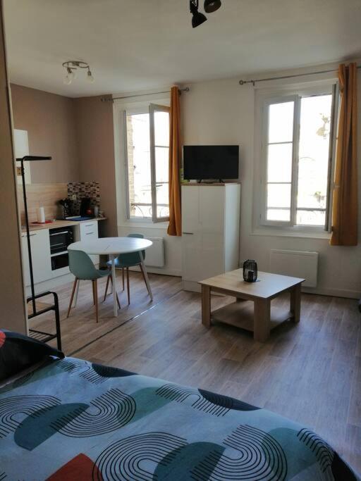 uma sala de estar com uma mesa e uma cozinha em Charmant studio -Dieppe centre em Dieppe